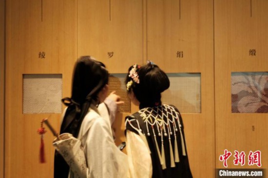 身着汉服的年轻人在中国丝绸博物馆里看展。毛瑜 摄